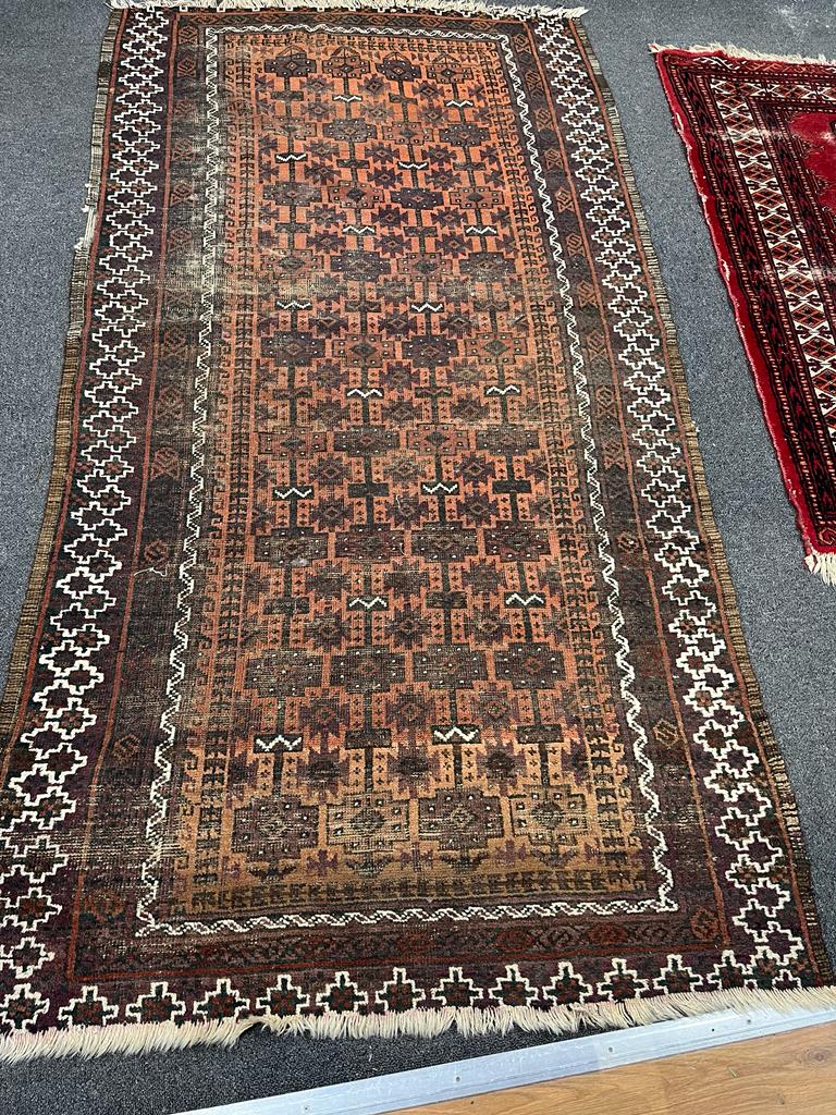 An antique Belouch red ground rug, 184 x 101cm together with a smaller Bokhara red ground rug